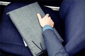 hand pakt tas met documenten van stoel